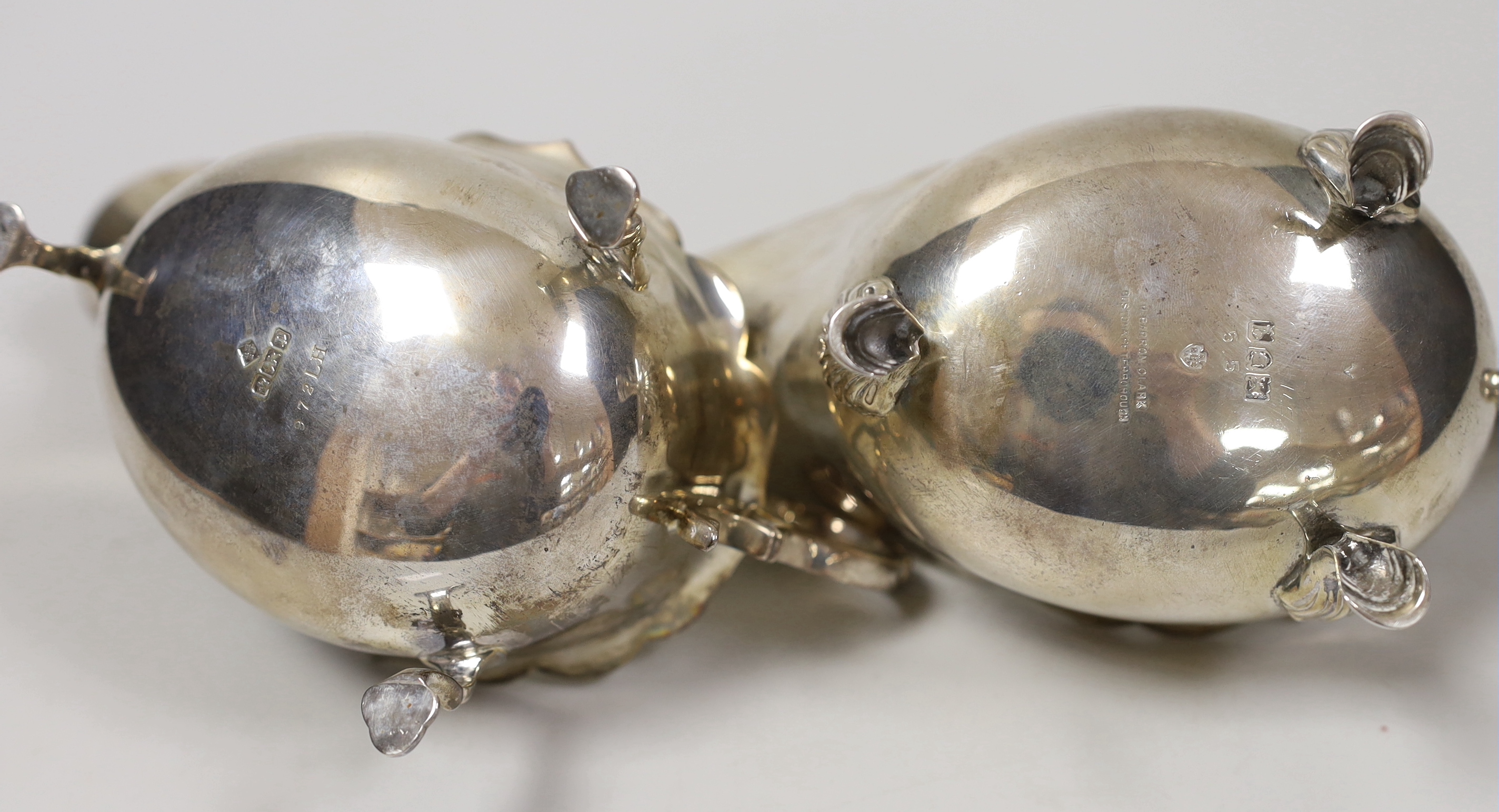 Two early 20th century silver sauceboats, with flying scroll handles, London, 1911 and Sheffield, 1907, 15.2oz.